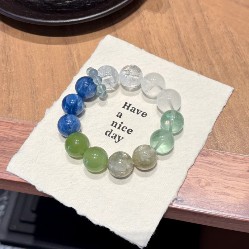 Large 15mm mixed gemstone bracelet by Dewery, combining natural beads of Vintage Kyanite, Xiu Jade, Green Fluorite, and Snowflake Phantom Quartz on a clean studio background.