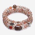 Multi-layer crystal wrap bracelet featuring 4-5mm natural rutilated quartz beads blended with a red agate accent and a shimmering grey moonstone.